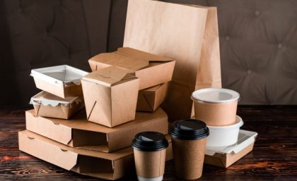 a pile of brown and white cardboard food boxes and bags